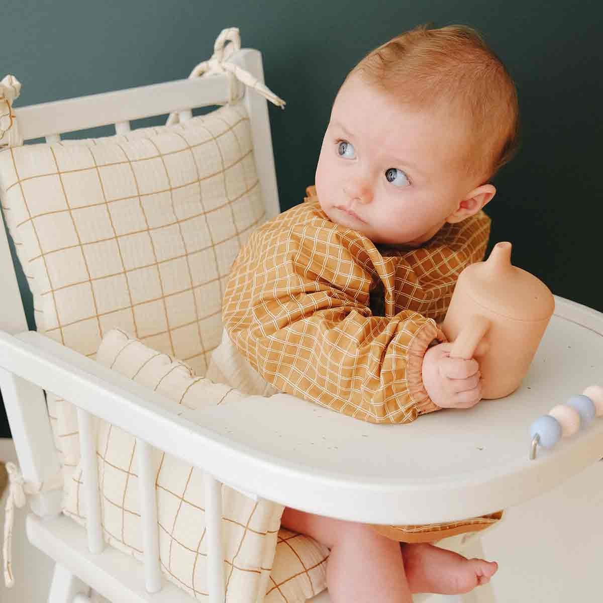 Baby with long-sleeved camel bib