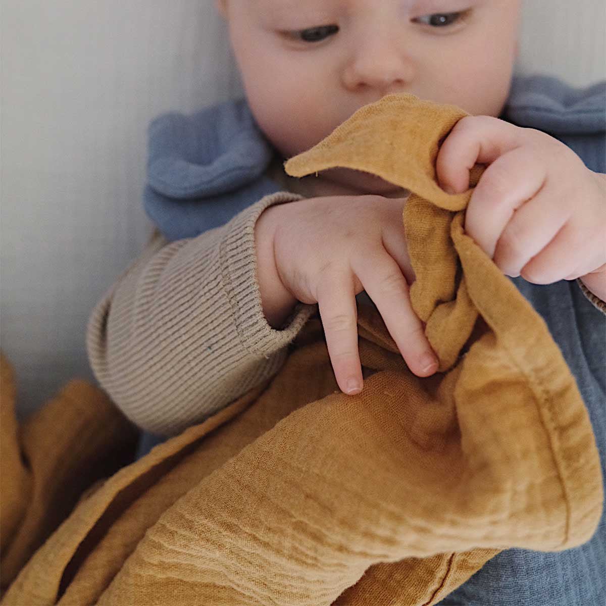 Bébé avec lange en gaze de coton camel