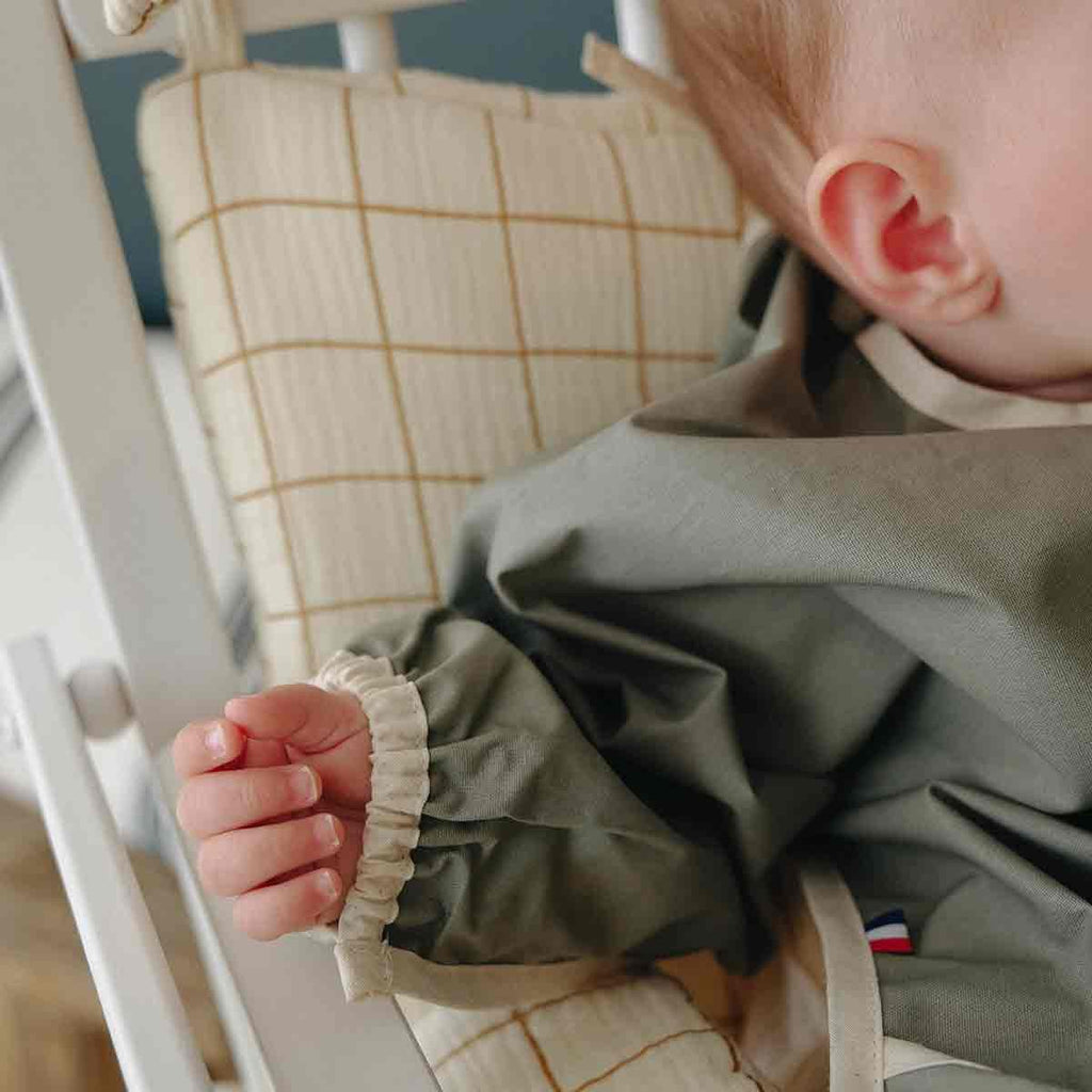 Sage green long-sleeved bib, close-up view