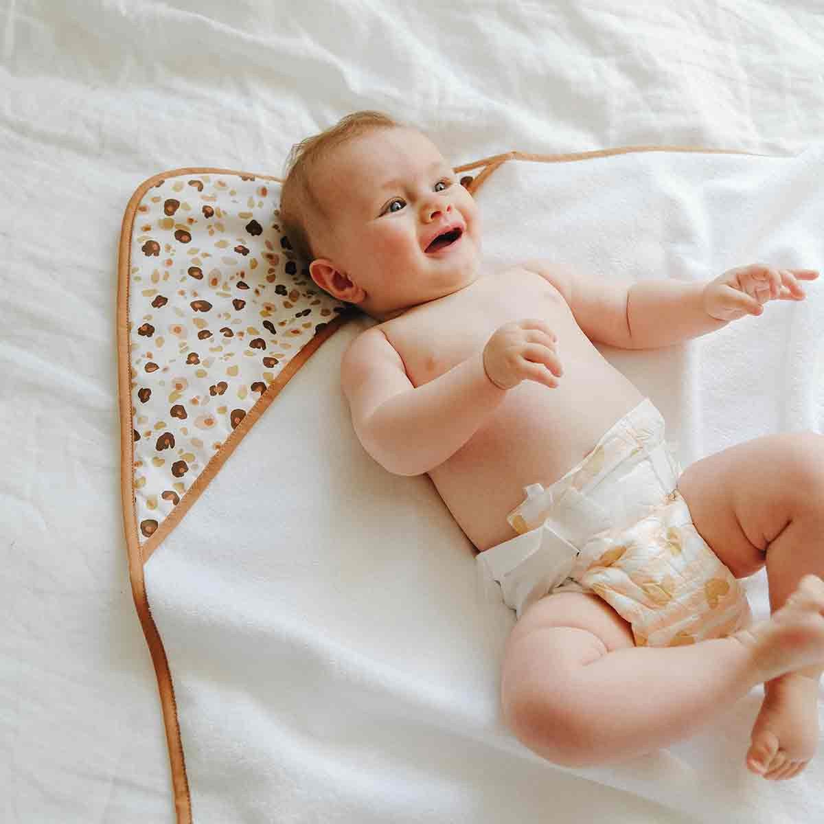 Baby lying on his leopard bath cape