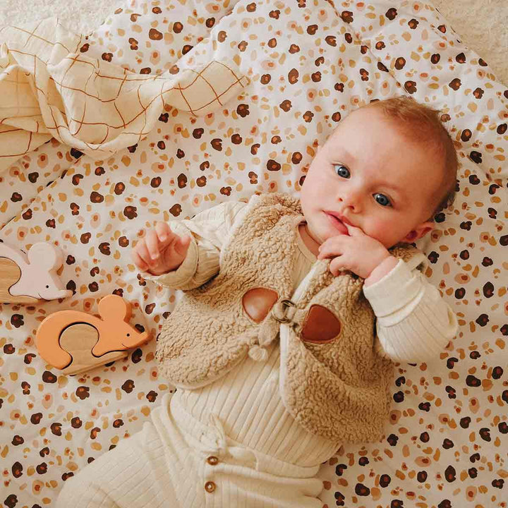 Bébé allongé sur une couette en coton léopard