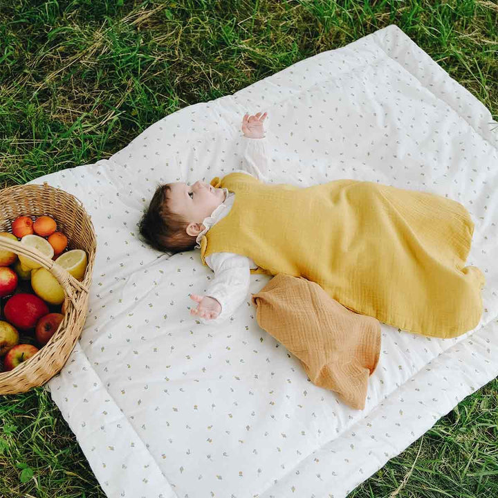 Bébé allongé sur une couette plein air