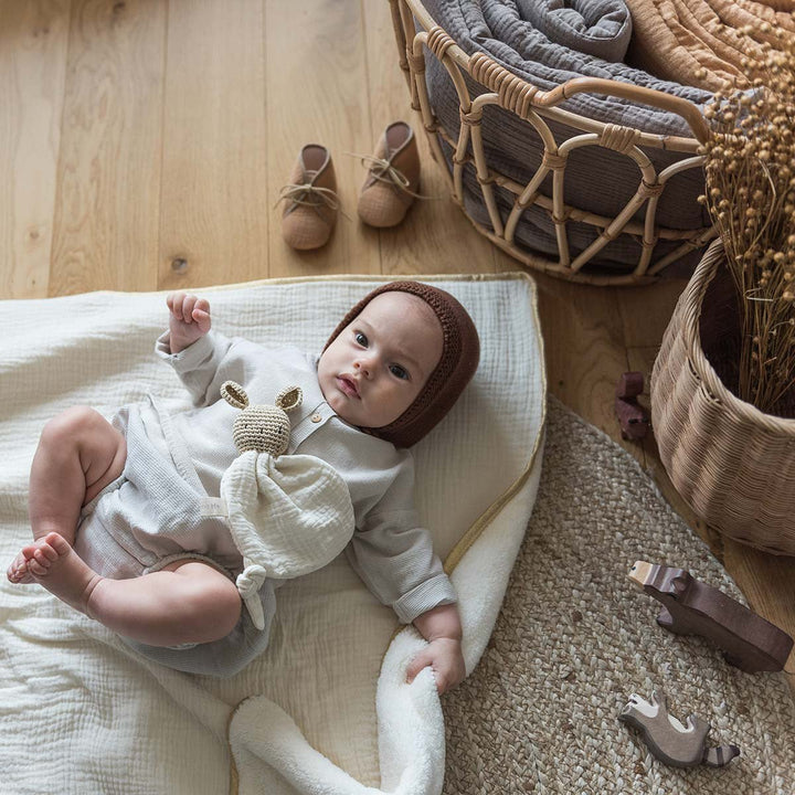 Bébé allongé sur une couverture polaire écru