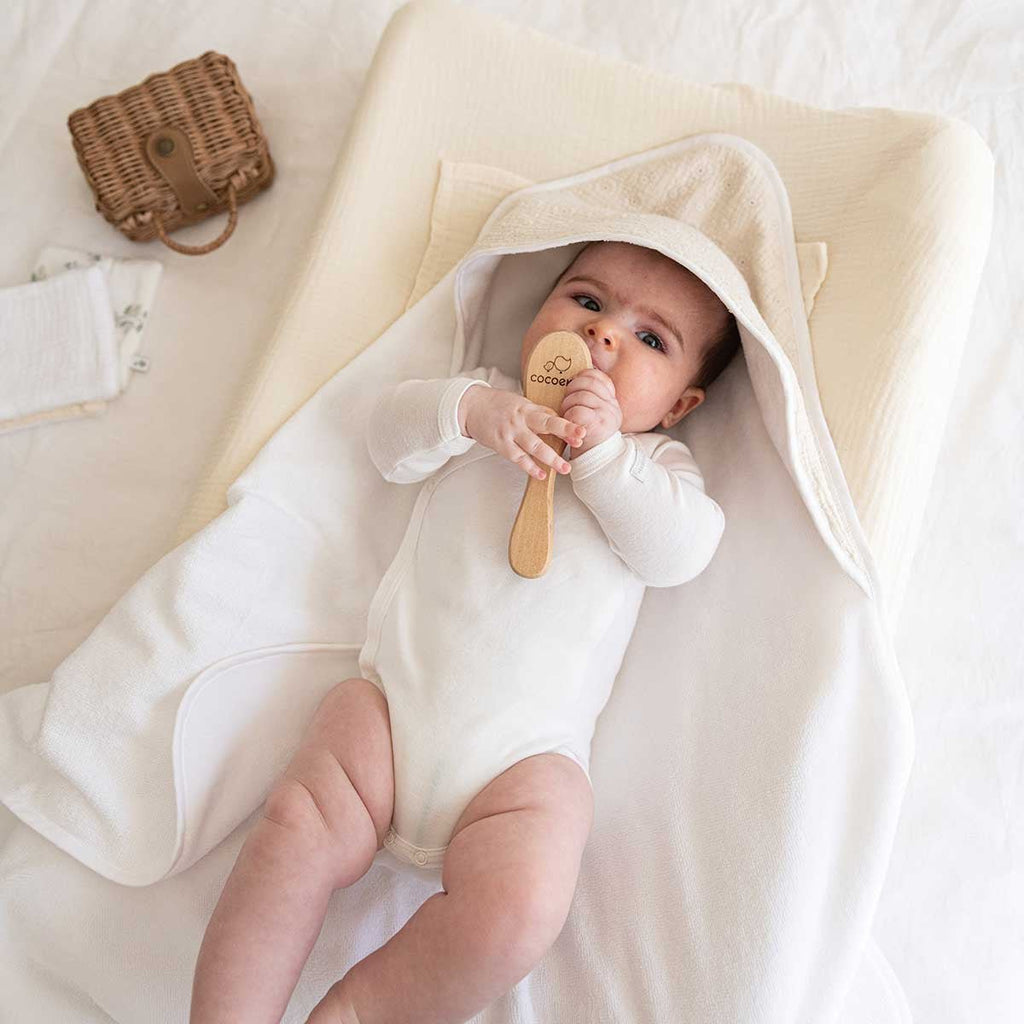 Baby lying on changing mat with ecru cover