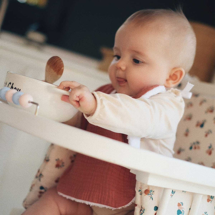 Bébé en train de manger avec son bavoir marsala