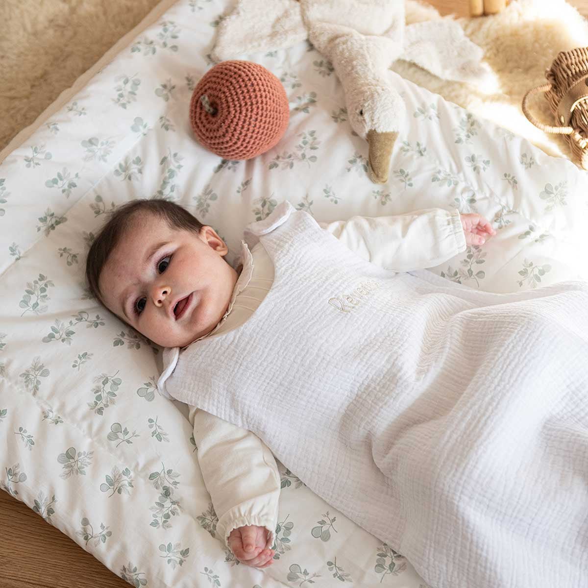 Baby wearing a white summer sleeping bag