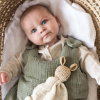 Baby with sage green sleeping bag