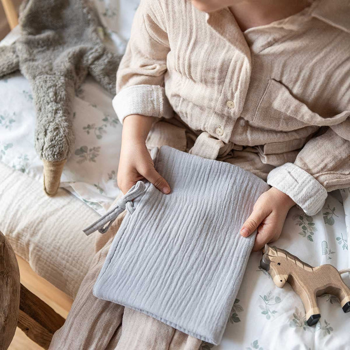 Bébé avec son protège carnet de santé gris clair