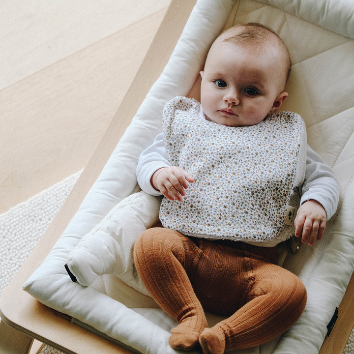 Bébé avec un bavoir fleurs fougère