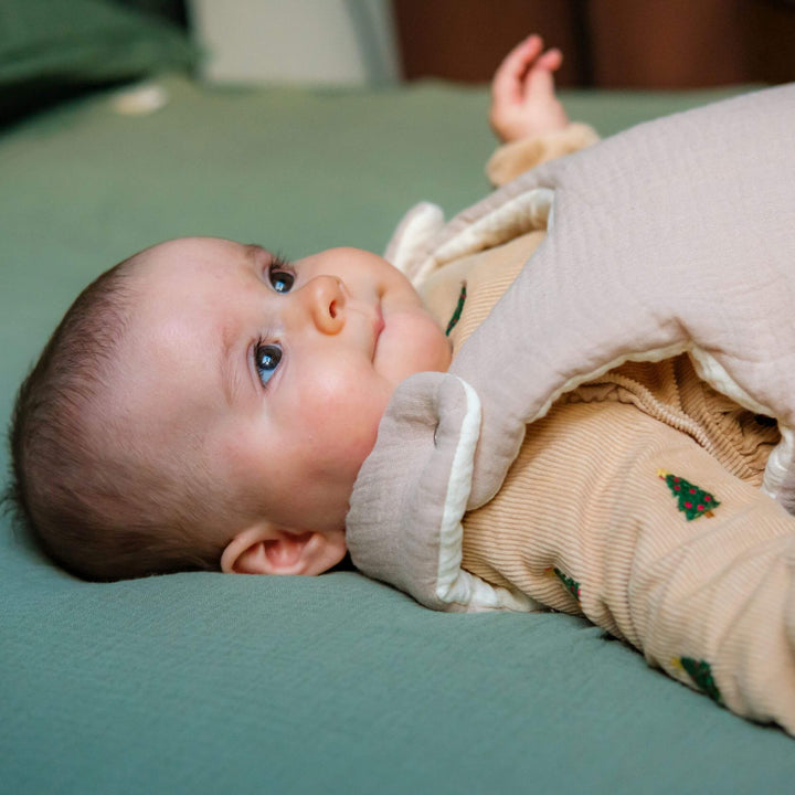 Bébé dans gigoteuse gaze de coton beige tog 2 vu sur le côté