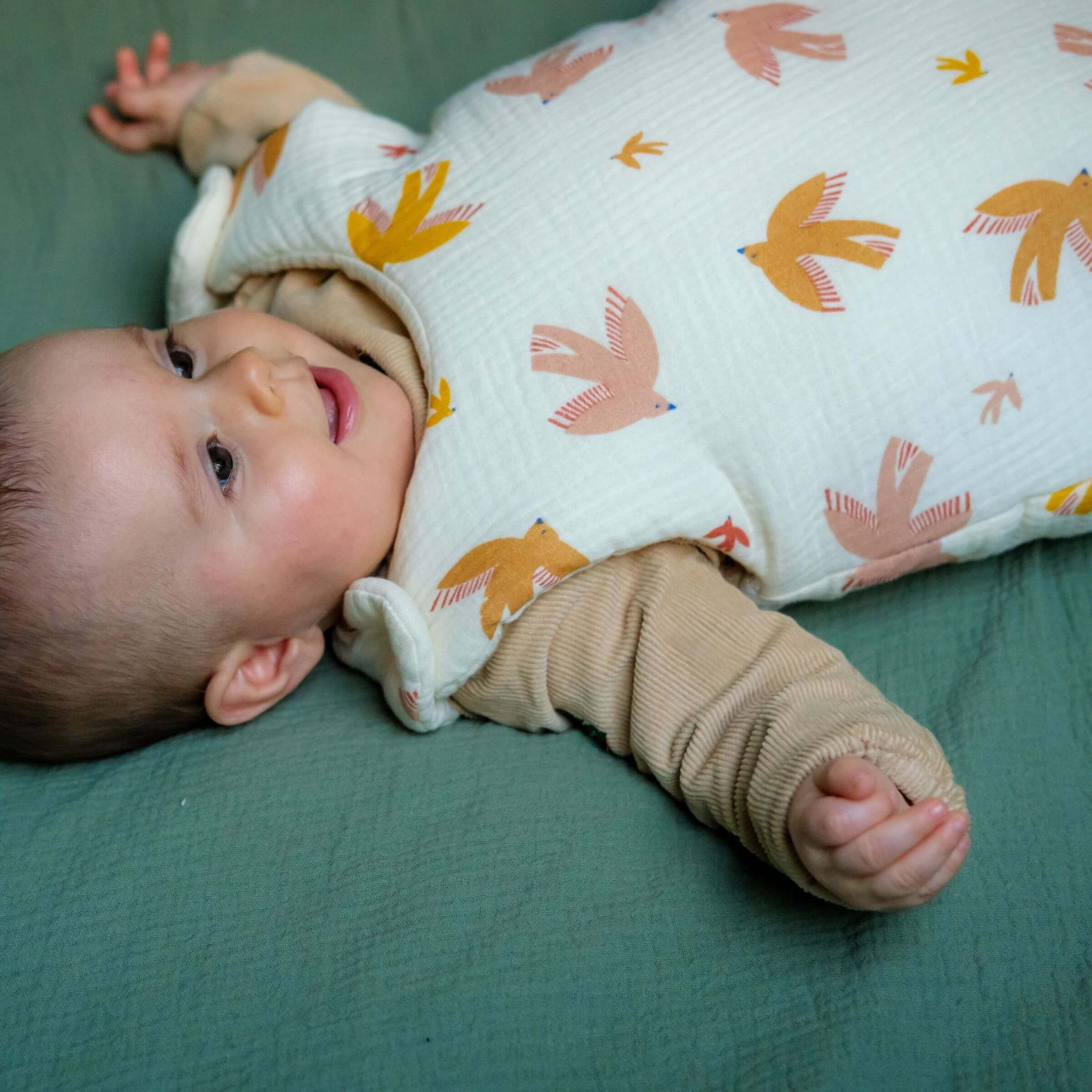 Baby in cotton gauze bird sleeping bag