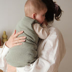 Bébé avec sa maman avec une gigoteuse hiver vert sauge