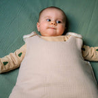 Baby in beige cotton gauze sleeping bag tog 2 seen from above