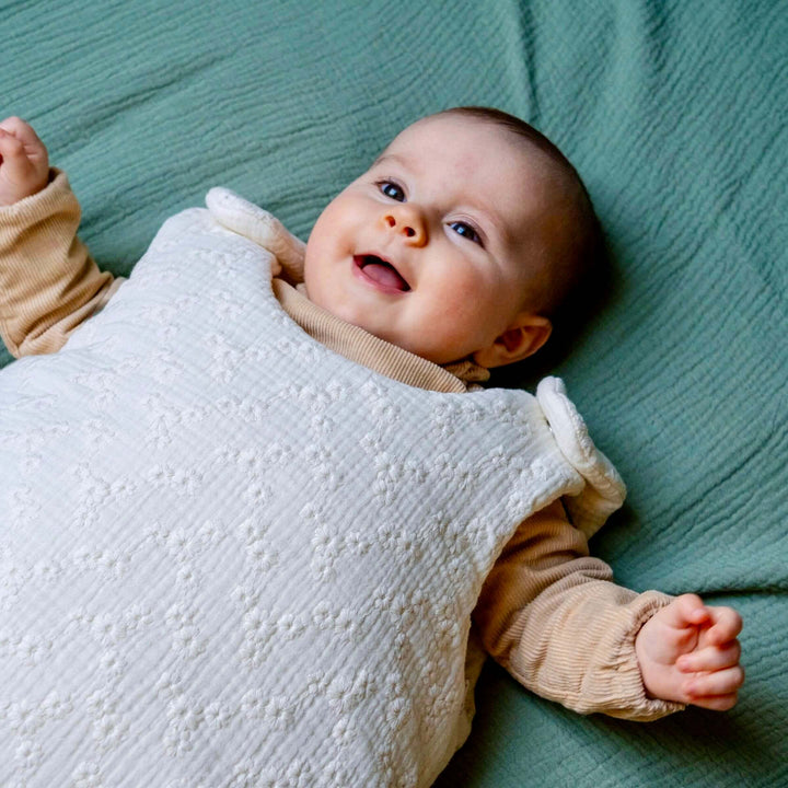 Bébé qui porte une-gigoteuse gaze de coton avec broderies