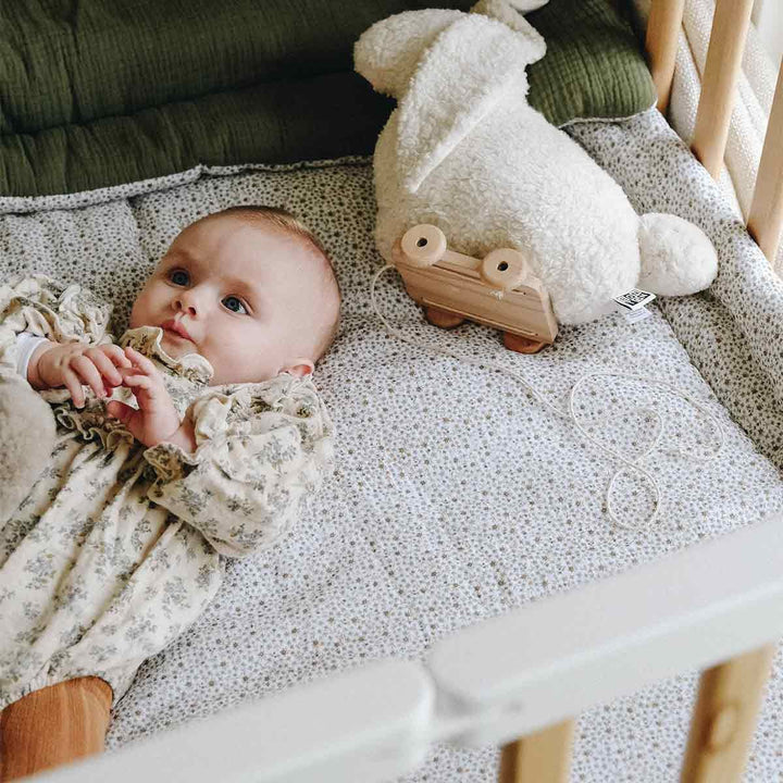 Bébé sur une couette en gaze de coton fleurs fougere