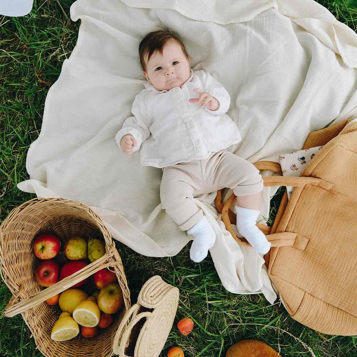 Baby lying on an ecru maxi diaper