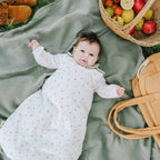 Baby lying on a sage-green maxi diaper