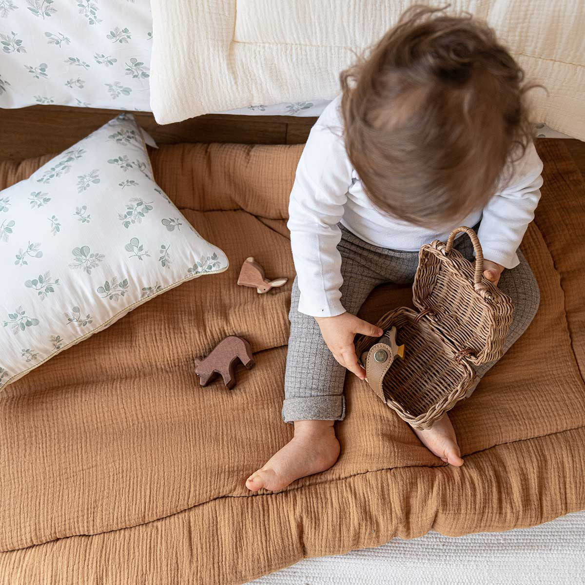 Bébé sur tapis d'éveil en gaze de coton camel
