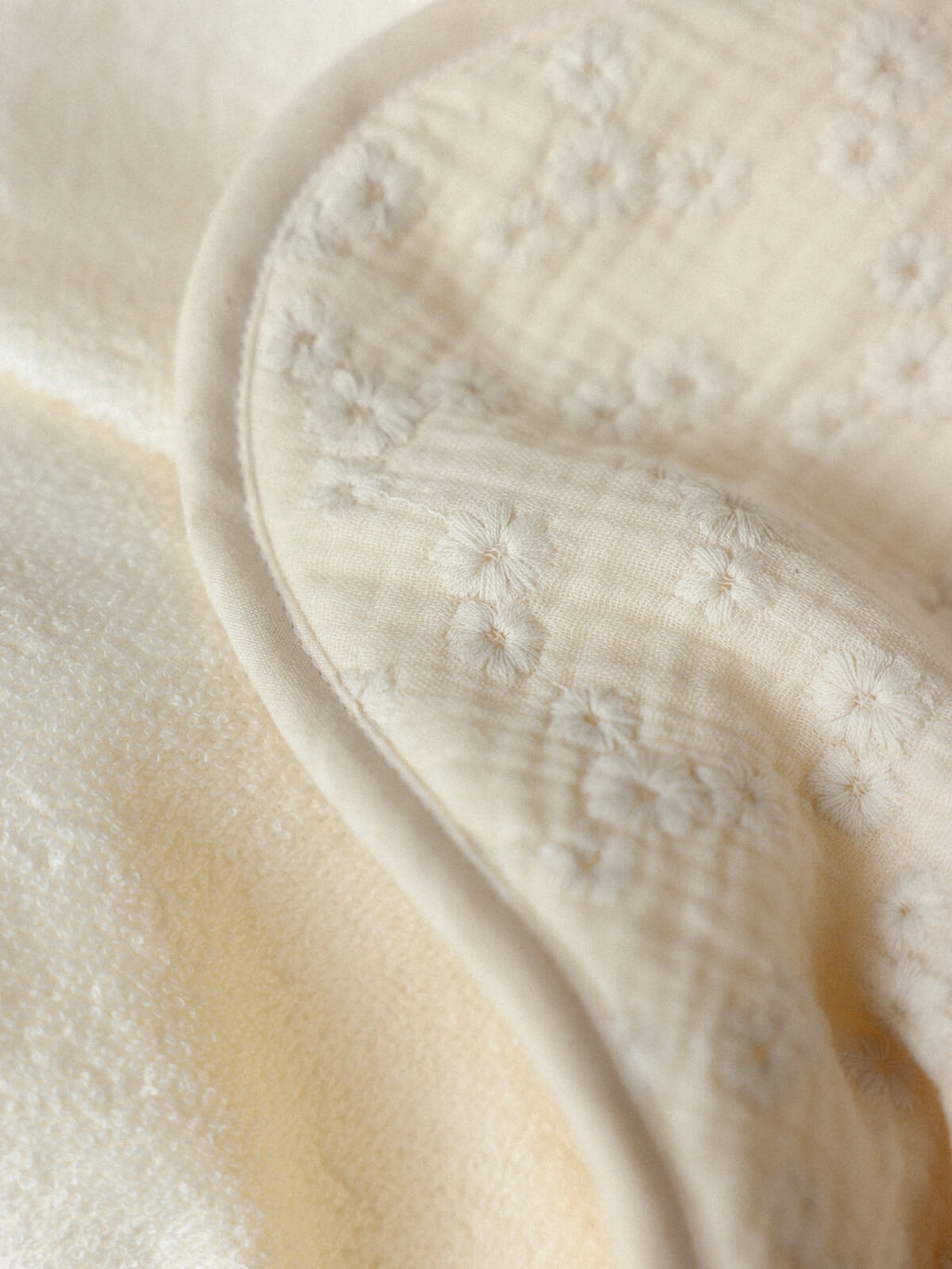 Détail de la gaze de coton brodée de fleurs et de la micro-éponge écrue