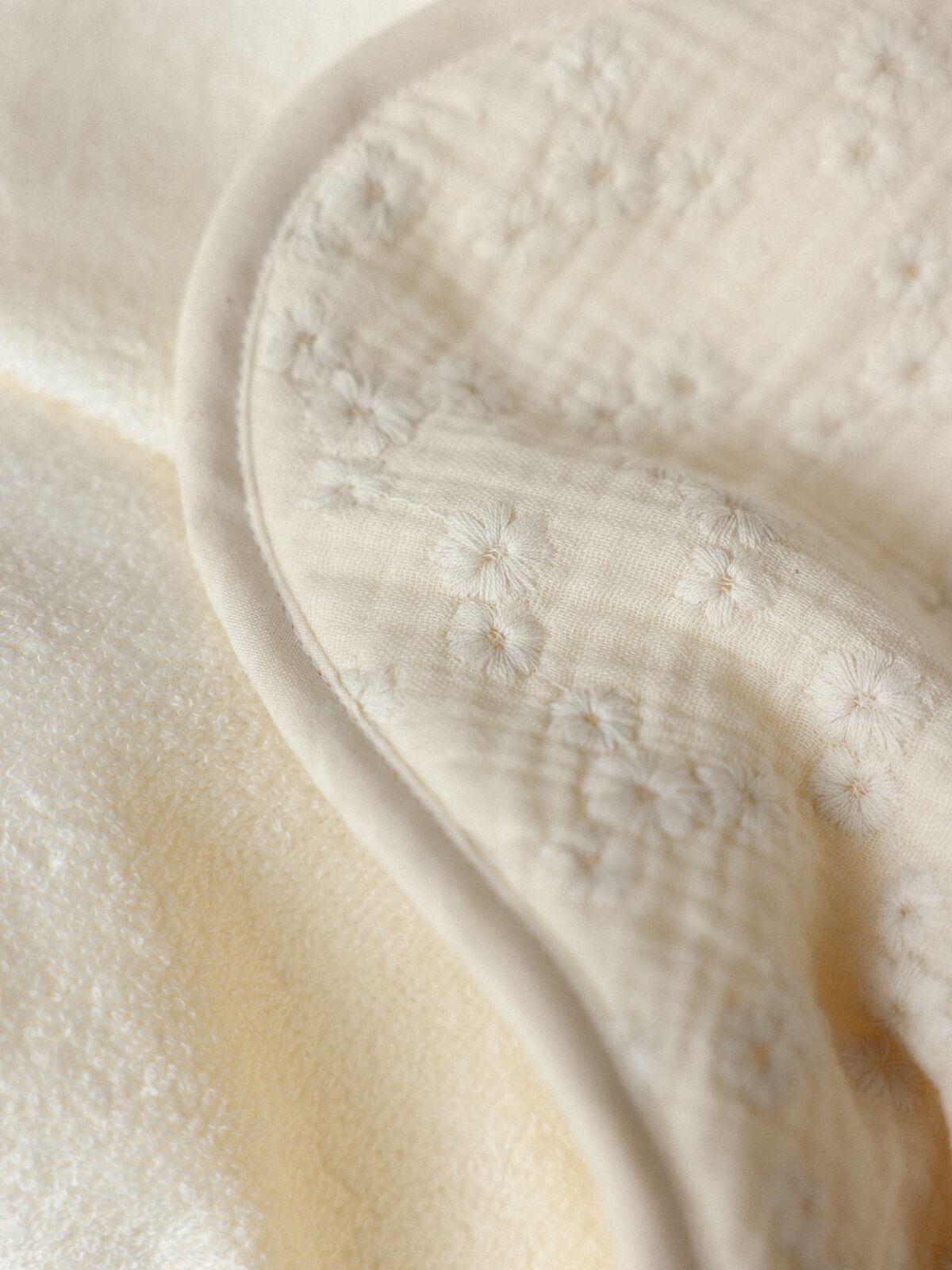 Détail de la gaze de coton brodée de fleurs et de la micro-éponge écrue