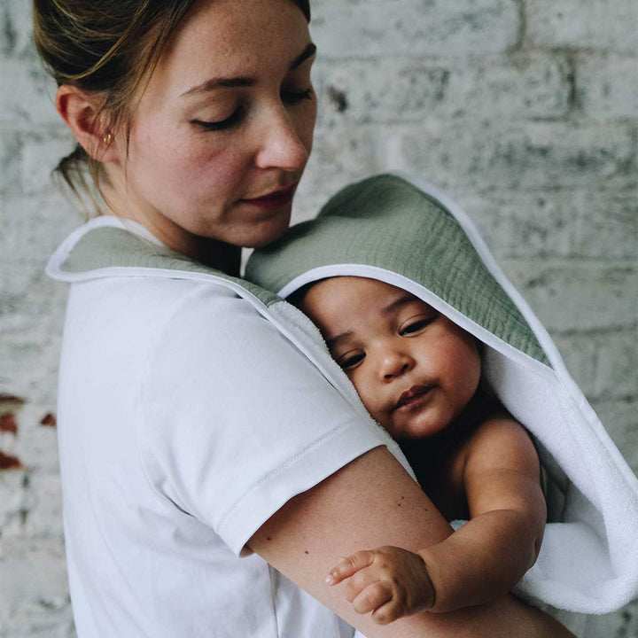 Bébé de près dans tablier de bain vert sauge