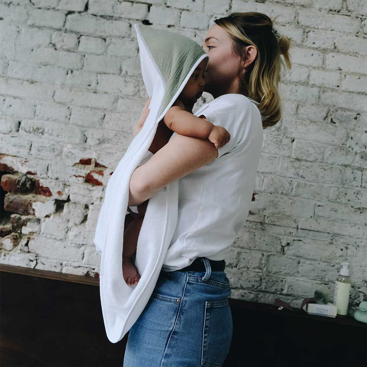 Baby and mom in a sage-green bathing apron