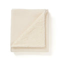 Folded ecru baby blanket, with one side made of cotton gauze and the other of sherpa fleece