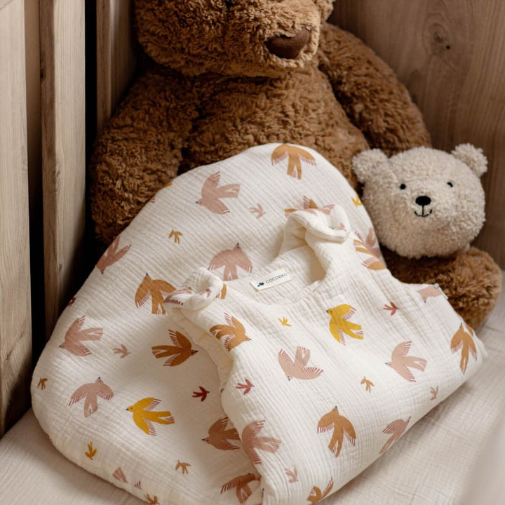 Gigoteuse hiver couleur écru avec motif oiseaux dans un lit bébé avec un doudou