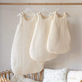 Ecru cotton gauze sleeping bags 0-6 months, 06-24 months and 24-36 months in a nursery