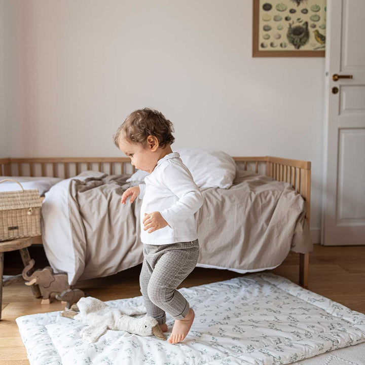 Housse de couette enfant en coton lavé blanc et biscuit dans un lit