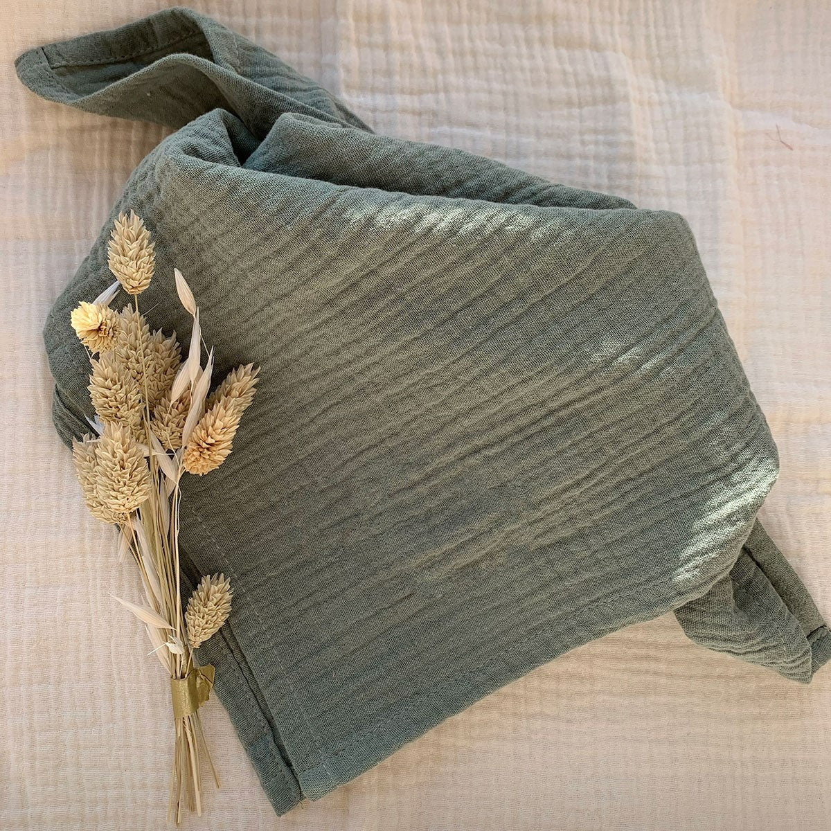 Close-up of sage green cotton gauze diaper