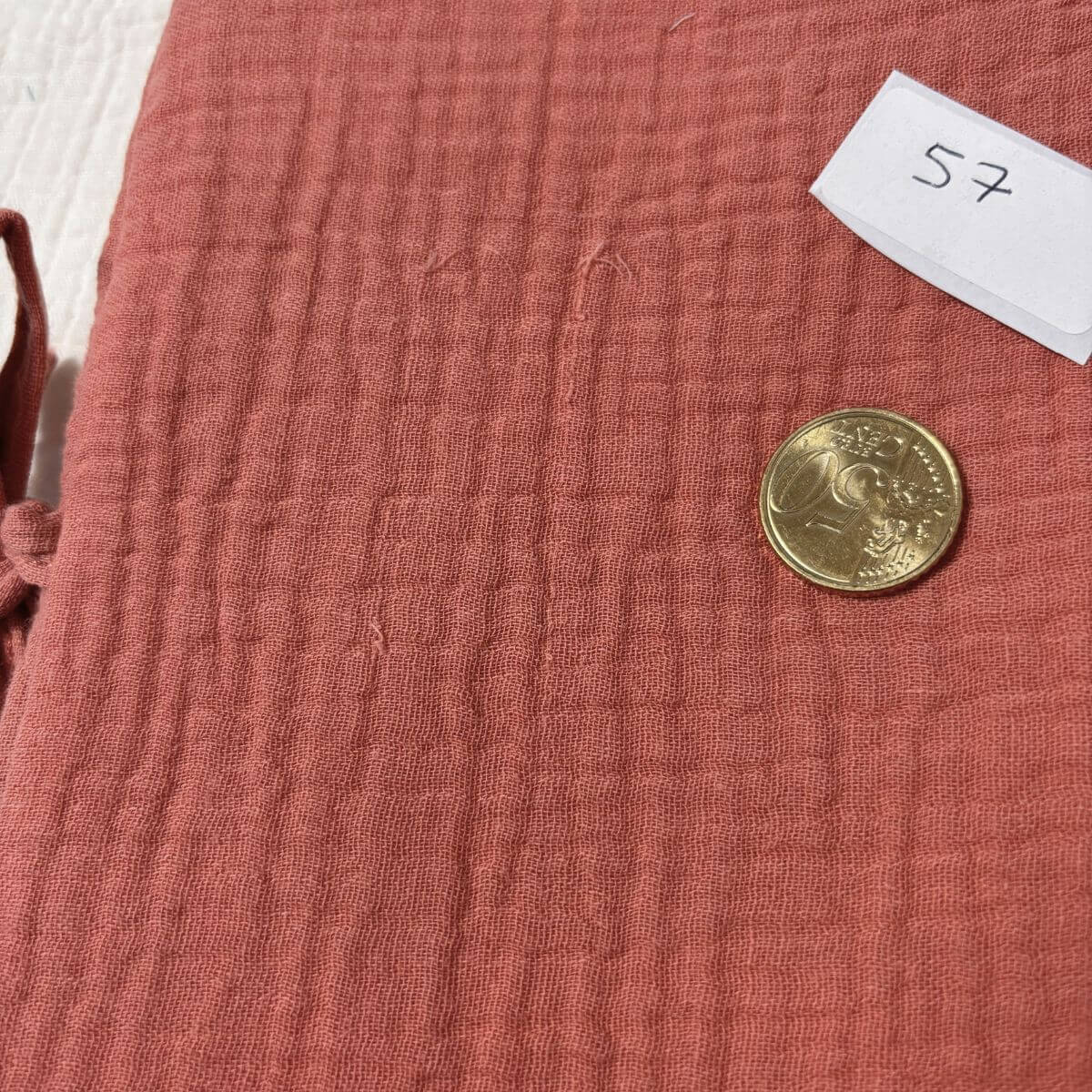 Petit défaut de tissage sur un protège carnet de santé marsala, pièce de 10 centimes pour l'échelle