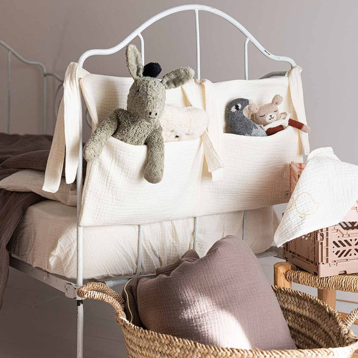 Range doudou écru sur un lit de bébé