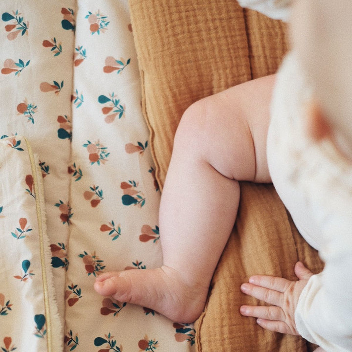 Bébé assis sur tapis de jeu bebe en coton bio