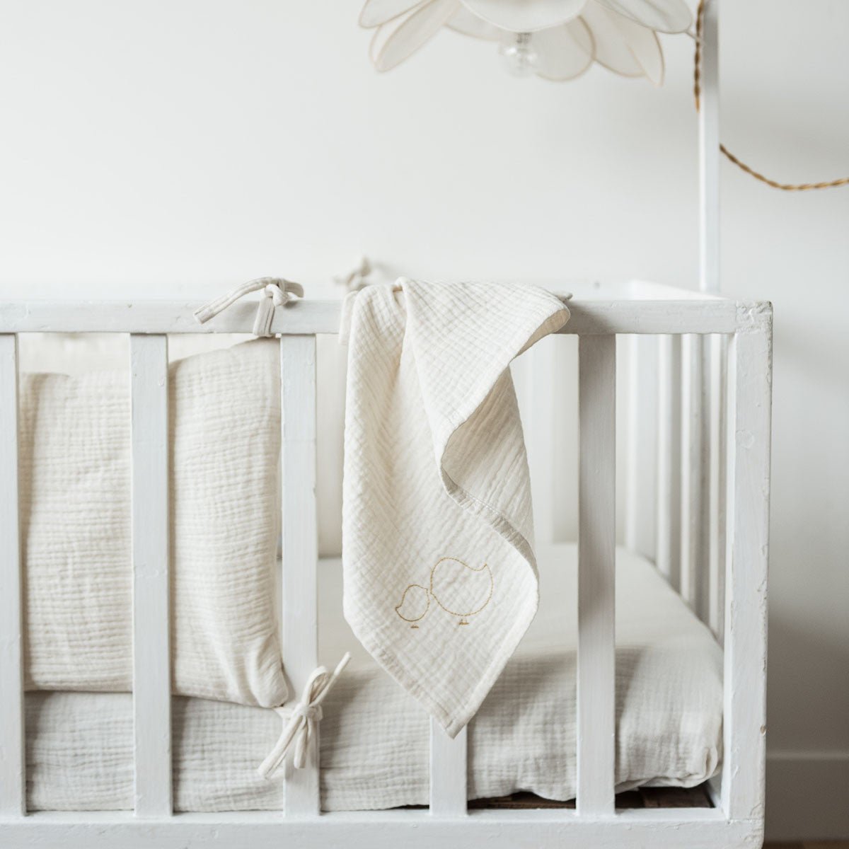 Tour de lit gaze de coton écru dans une chambre de bébé