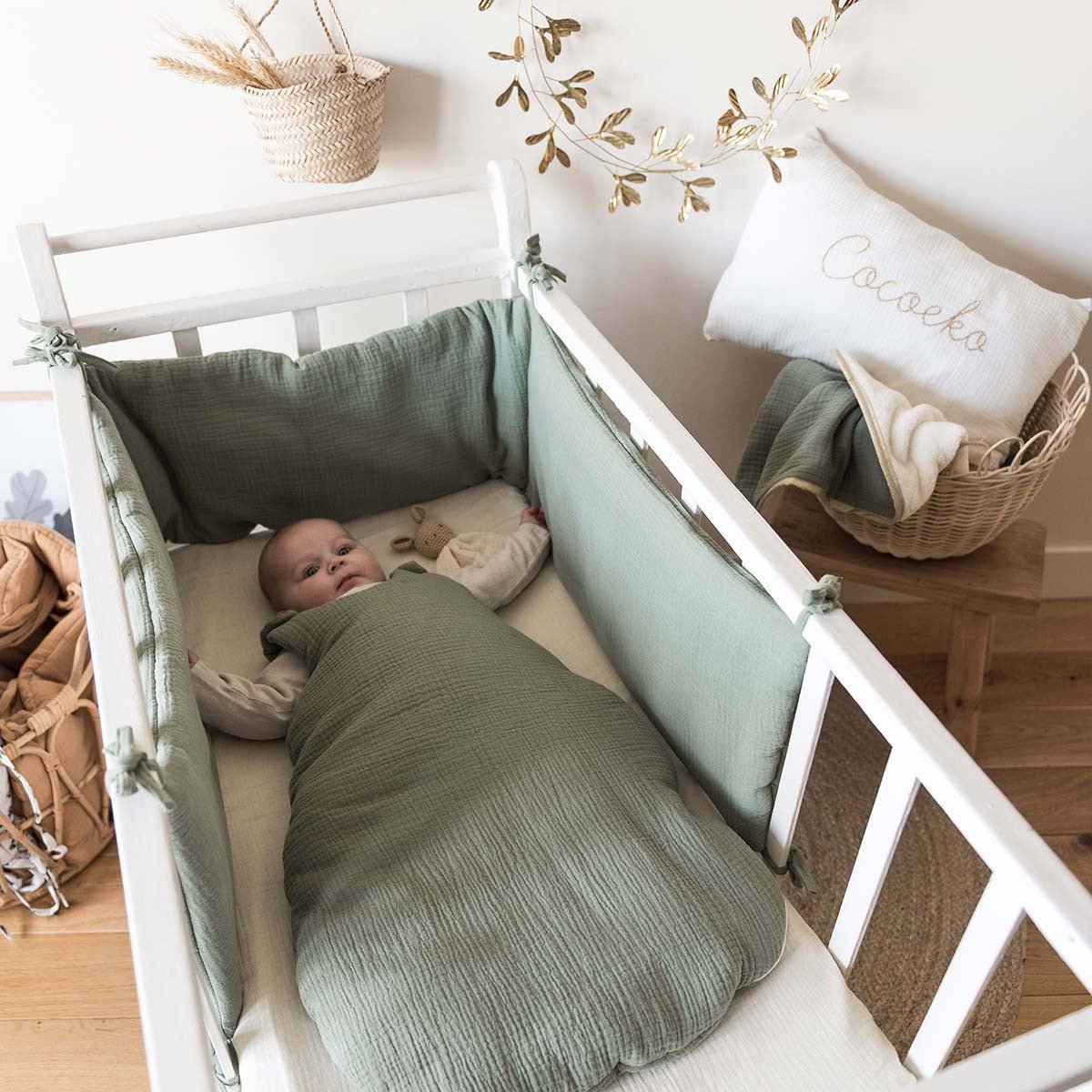 Tour de lit vert sauge dans une chambre de bébé