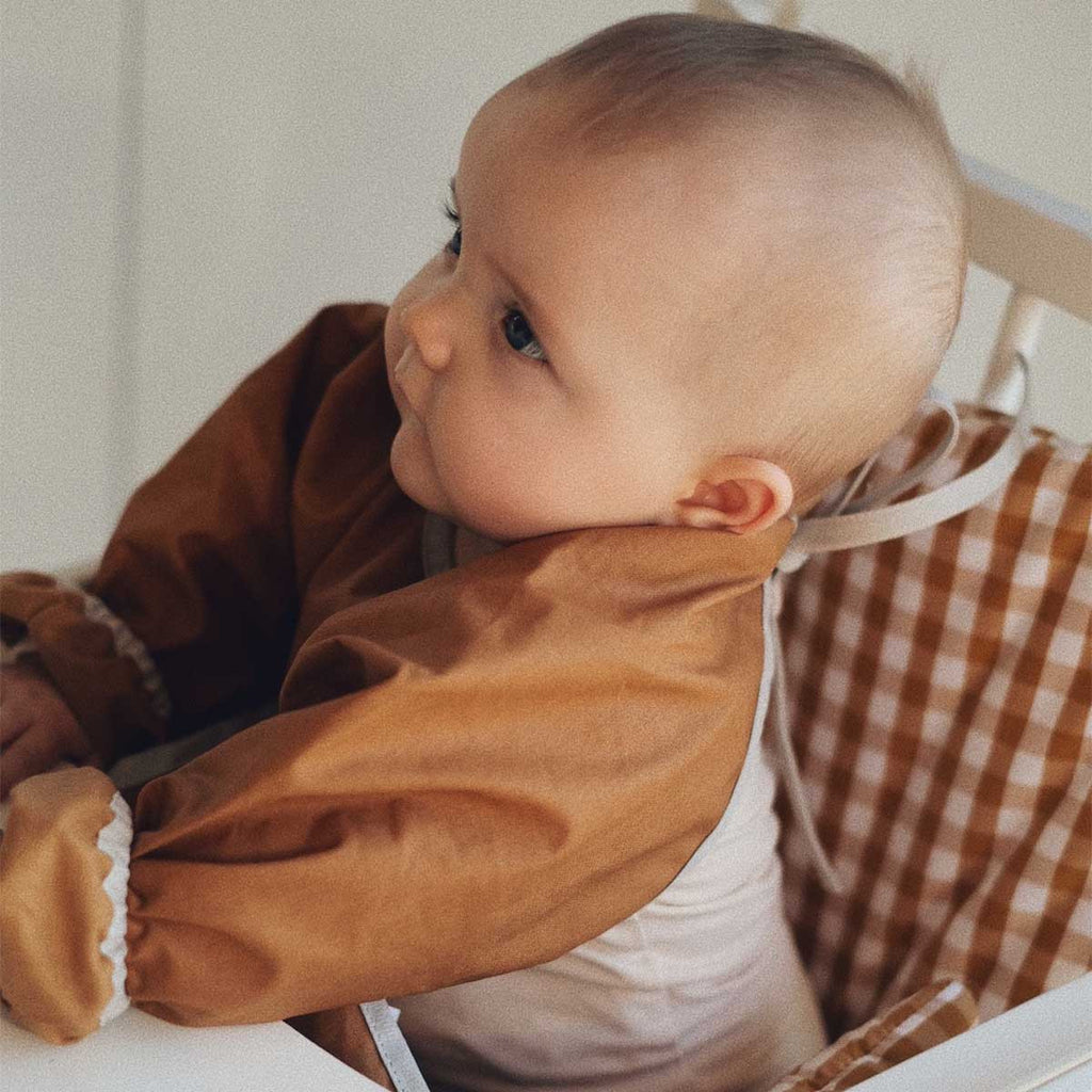 View of the back of the long-sleeved plain camel bib