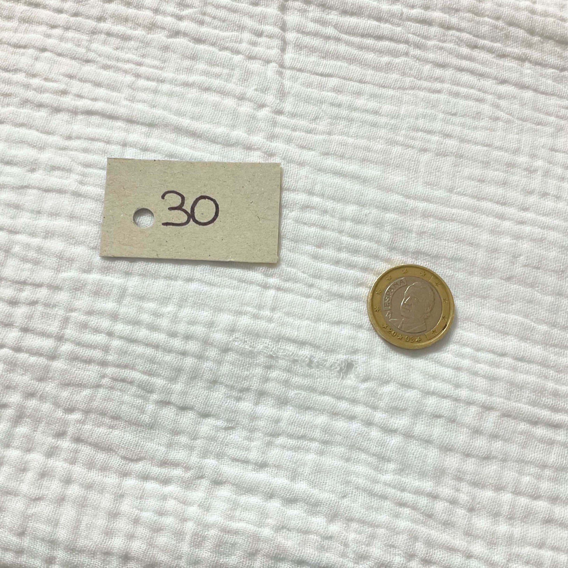Zoom in on the defect in the gauze on the white knotted curtain