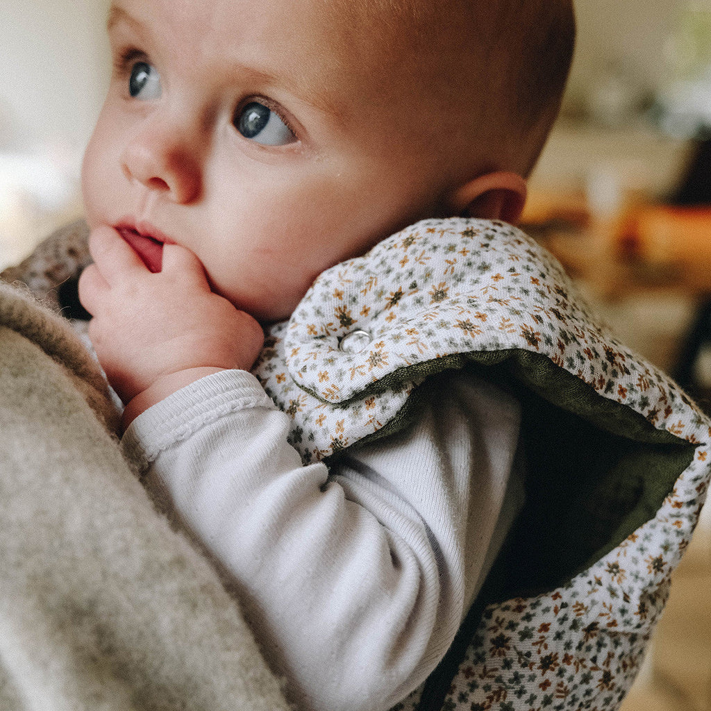 Baby in flowered sleeping bag, close-up view